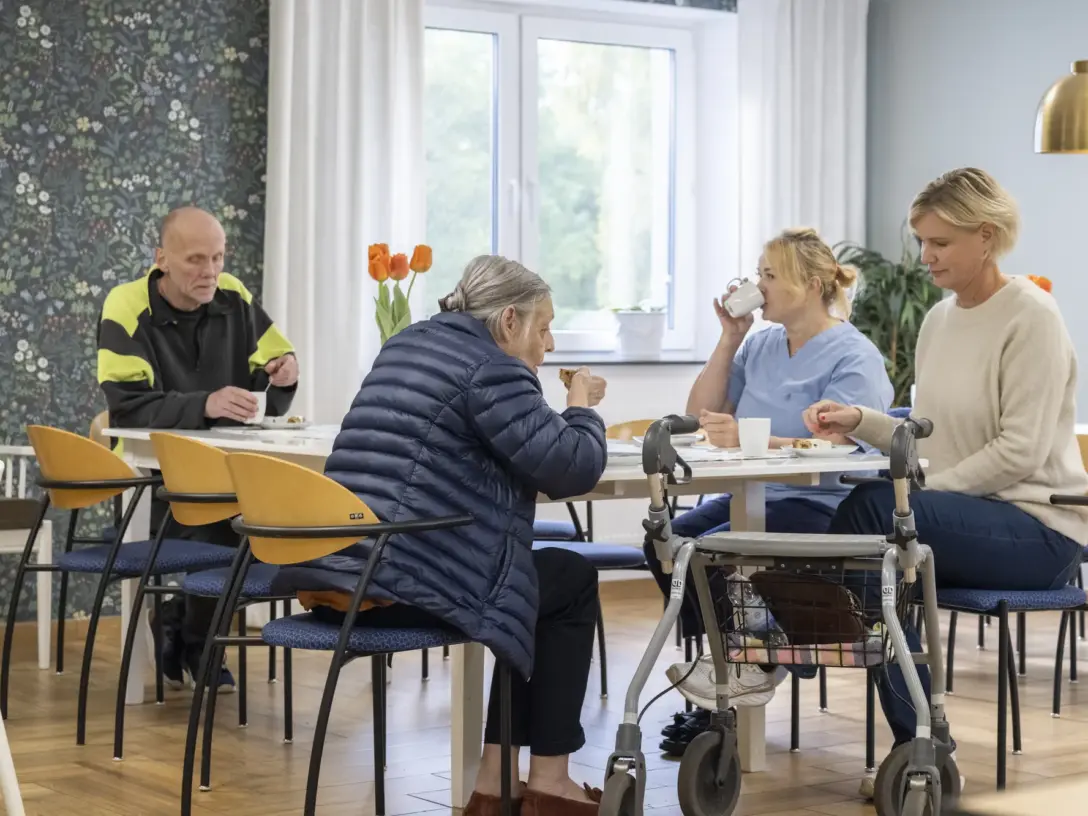 Fika vid långbordet i sällskapsrummet med tulpaner på borden