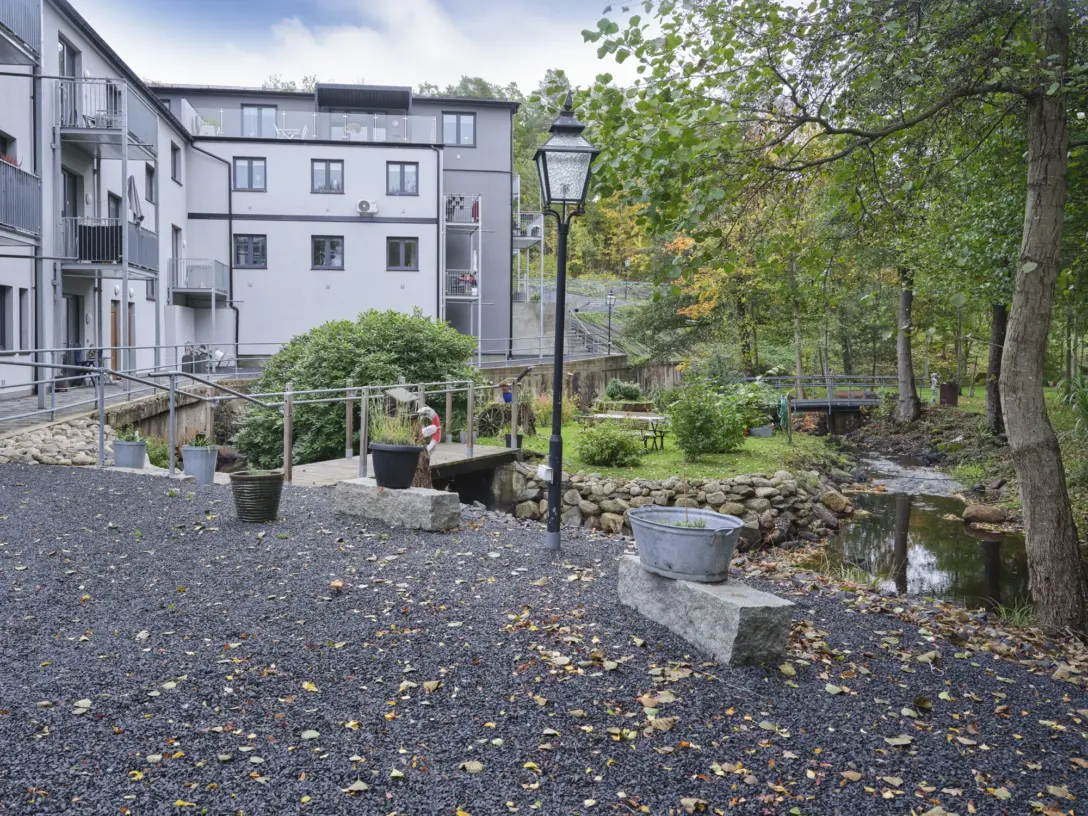 Grusad gång från huset ner mot ån och trädgården, med en gammal lykta