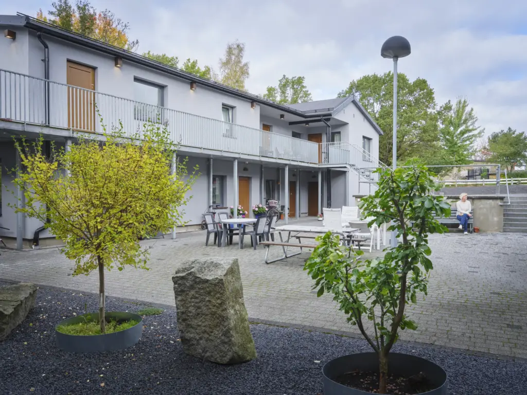 Innergården med svalgångar, träd i krukor och bord för sällskap