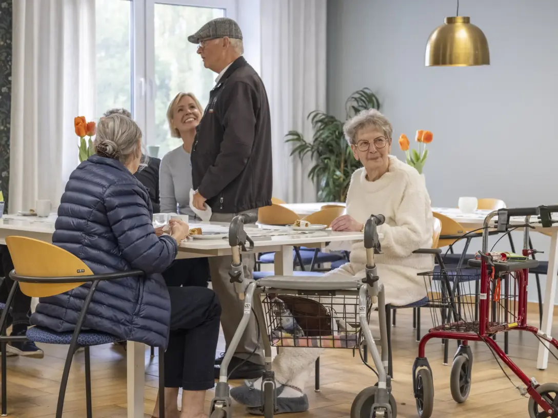 Boende pratar och skrattar vid fikabordet